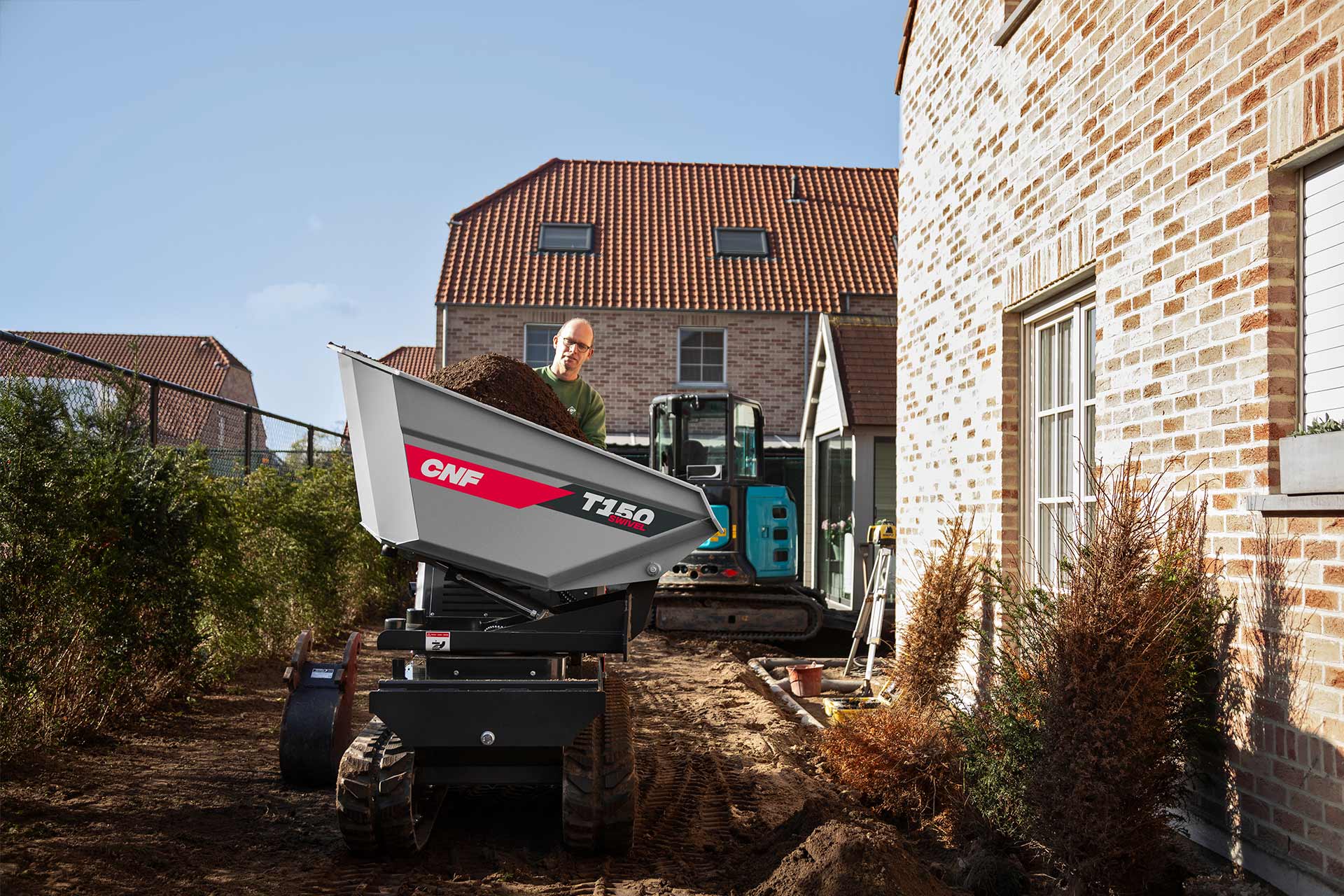 A small CNF tracked swivel dumper working beside a house.