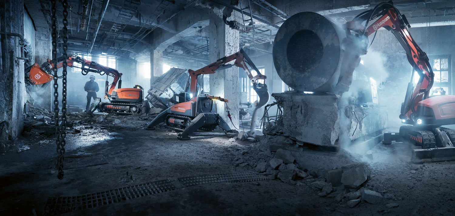 Three Husqvarna robotic diggers working in an industrial environment.